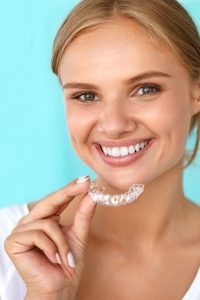 blonde girl holding invisalign